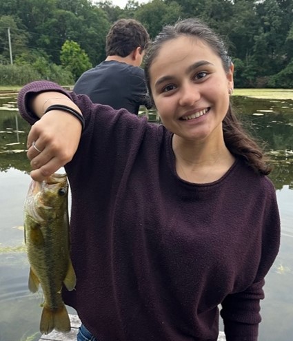 Nadia Rouag after catching her first fish; Cousin Zach in background