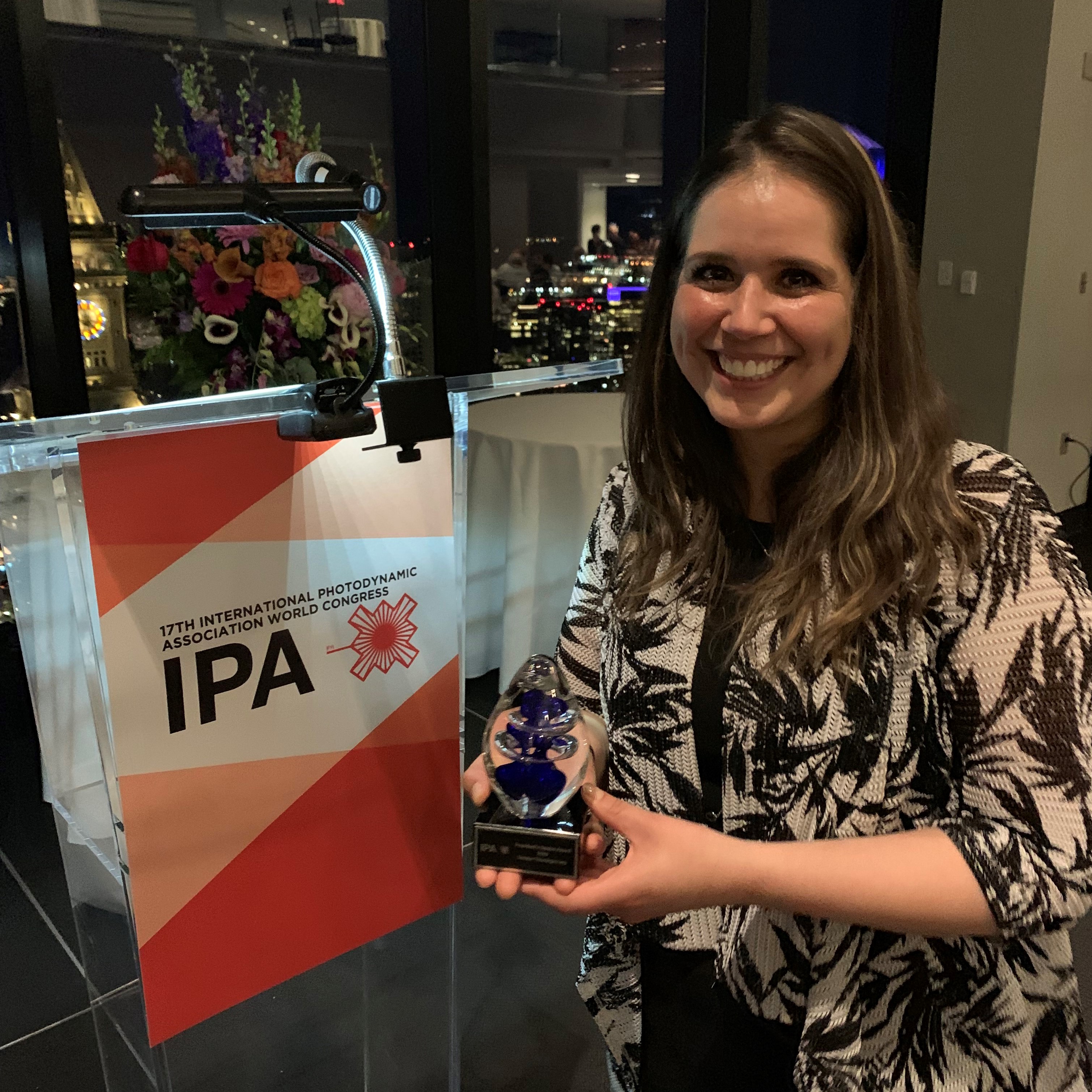 Cristina Romo, Head of Microbiology at Sinuwave Technologies Corporation, accepting the International Photodynamic Association's 2019 President's Choice Award on behalf of Sinuwave.