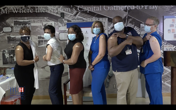 Staff at Howard University Hospital strike a pose to show off their bandages after taking the coronavirus vaccine shot. 