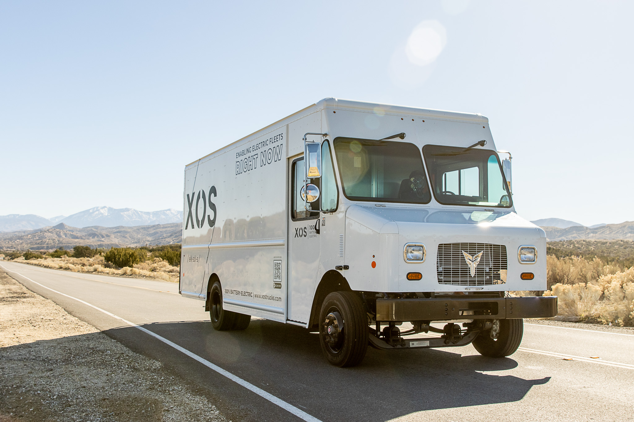 Black and white Xos stepvan in desert