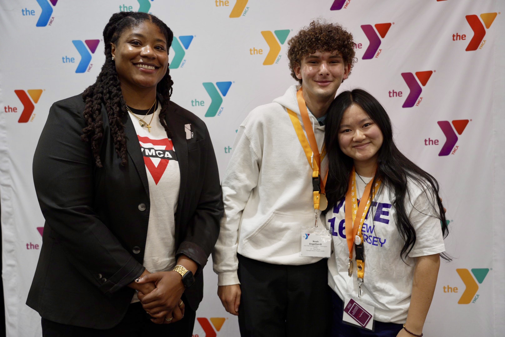 YMCA of the USA Director of Teen Strategy, E Mitchell, congratulates 2026 Changemakers Summit winners Anna H. and Noah E. (River Crossing YMCA, NJ) wh