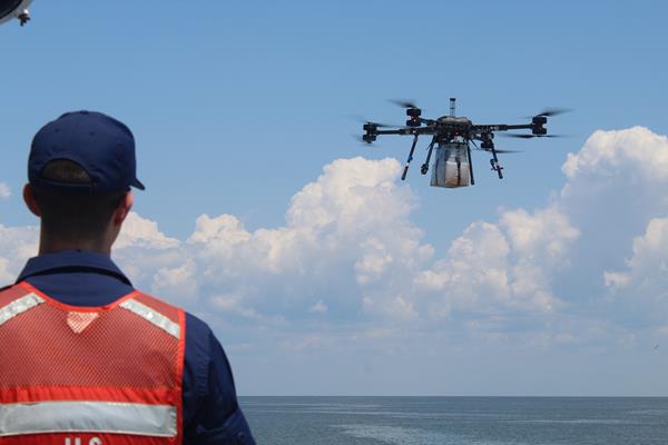 A Coast Guardsman aboard the USCGC Lawrence Lawson off the coast of Cape May, New Jersey awaits the arrival of an unmanned aircraft system transporting a case of First Strike Rations and a case of bottle water from the Cape May-Lewes Ferry Terminal in Cape May, New Jersey, July 25, 2019. The UAS test flight was conducted to learn about the potential use of UAS to deliver materials to areas applicable in supporting warfighters in austere environments and on ships, in addition to continental United States disaster relief. (Photo by Alexandria Brimage-Gray /DLA Troop Support)