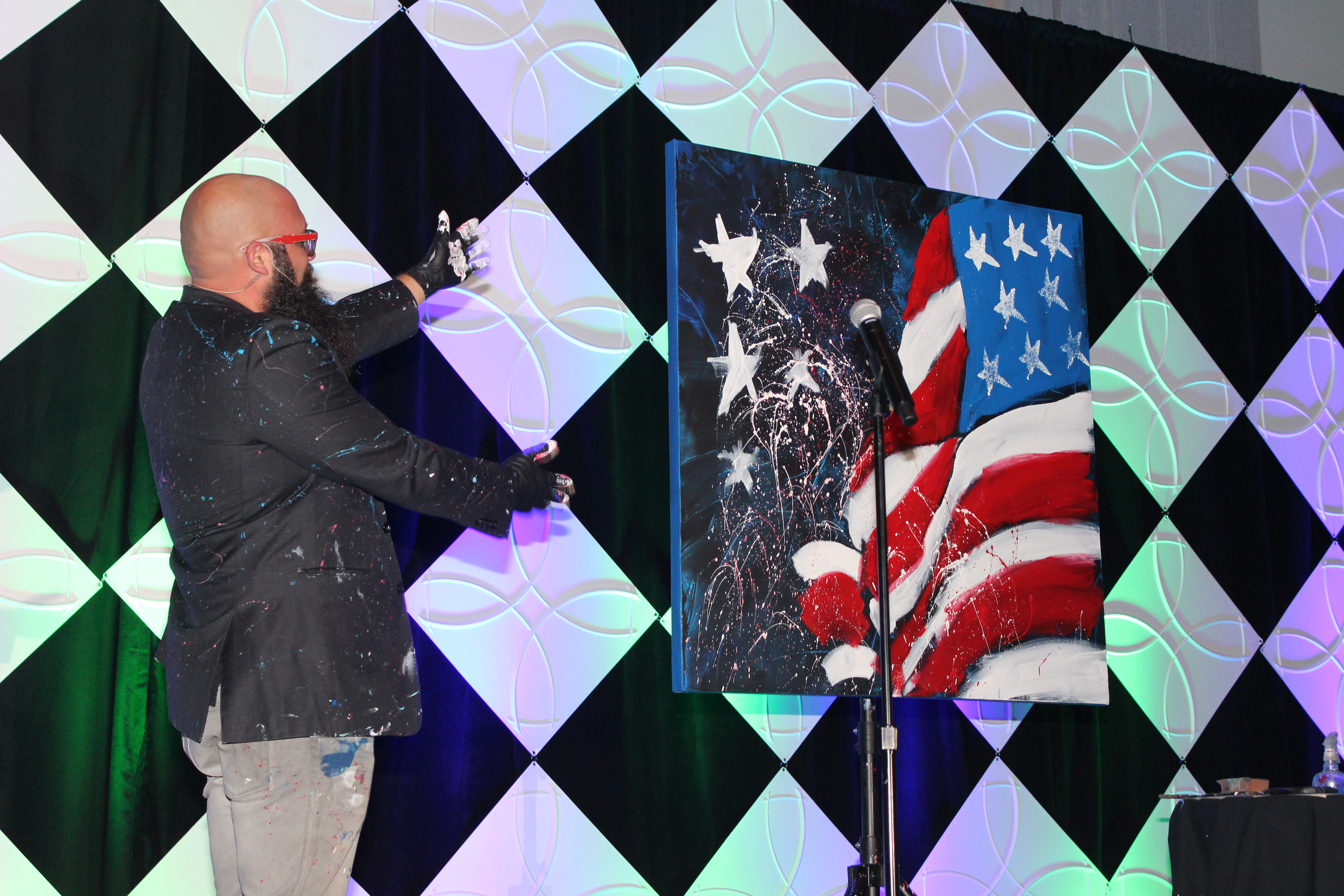 Singer/Painter Joe Everson shows off the final product of his painting after creating it live while singing America the Beautiful. 