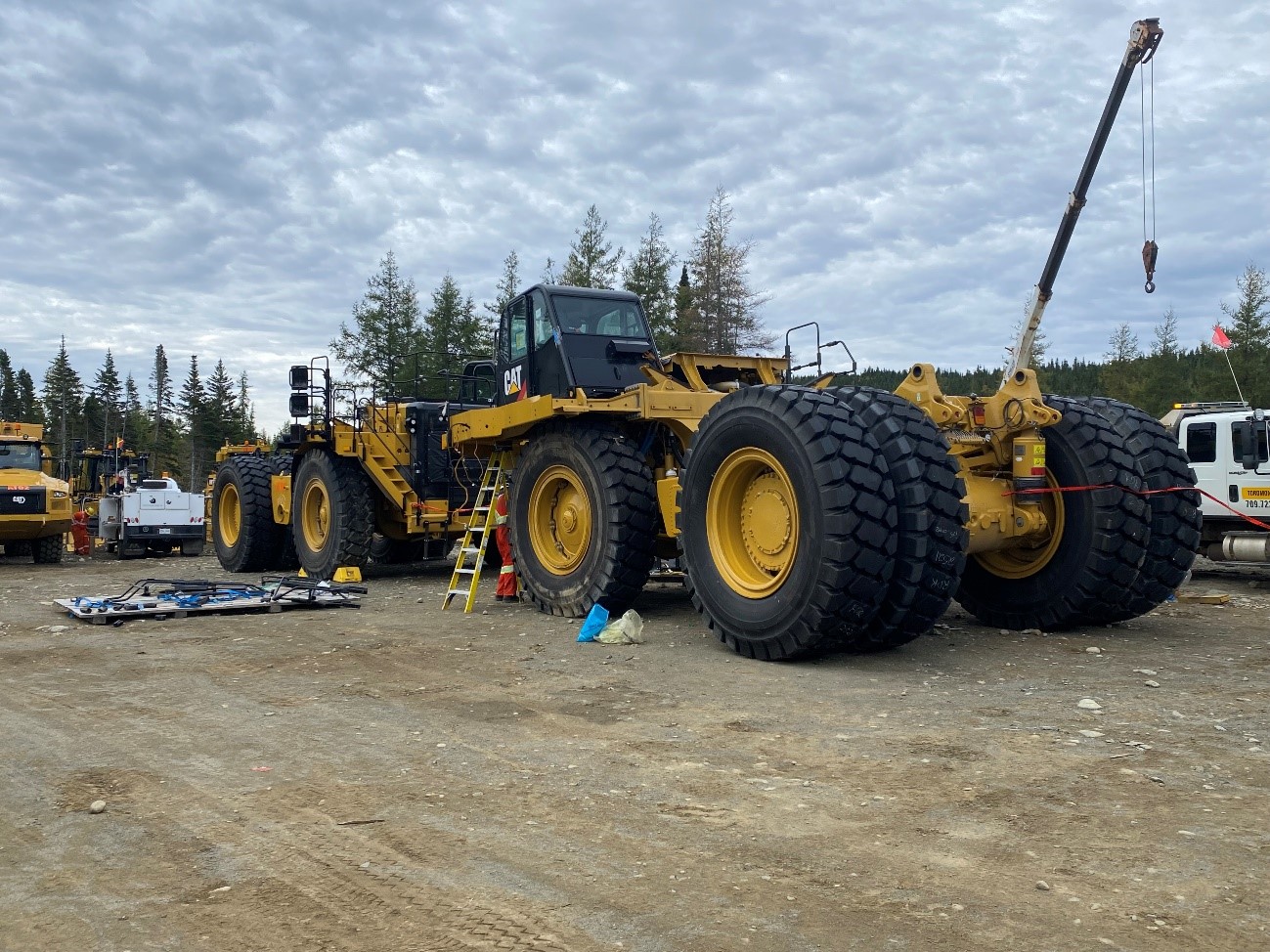 Caterpillar 6020 shovel (top) and two Caterpillar 777 100t mine trucks undergoing on-site preparation (bottom)