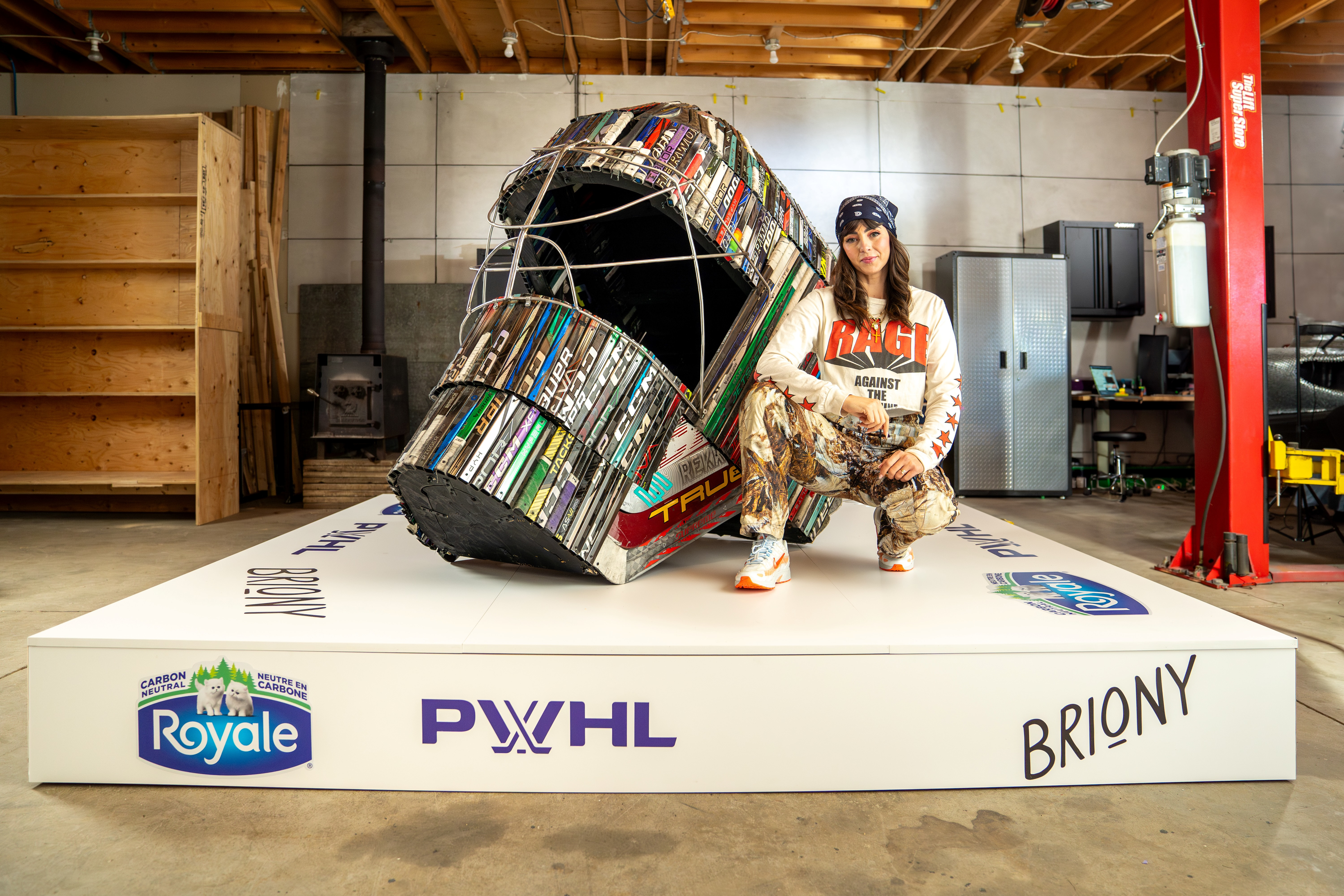 Commissioned by Royale, Canadian artist Briony Douglas poses with The Inaugural Six - crafted with the very hockey sticks used in the PWHL's first season.