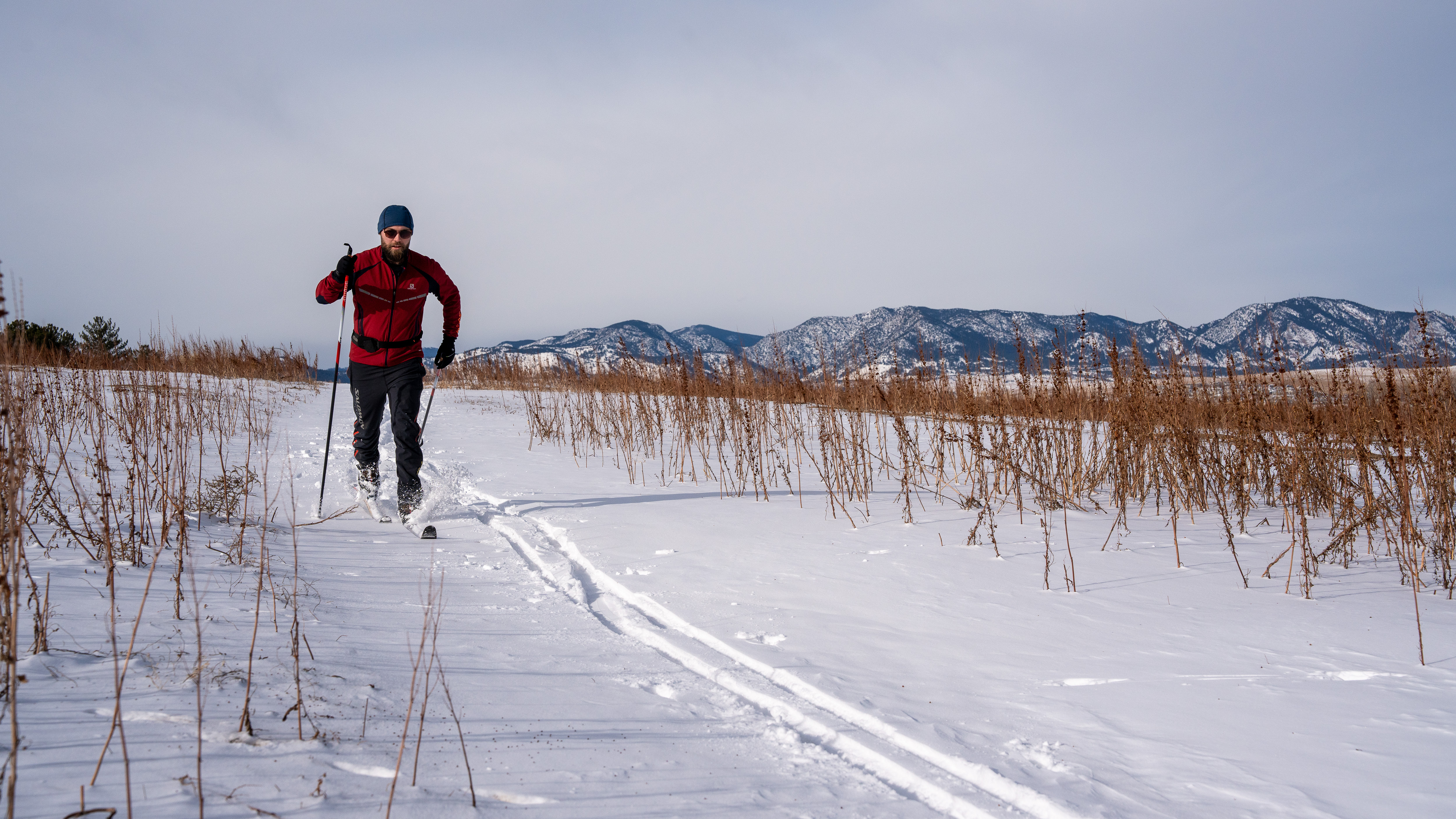 A man cross country skiing outside in the snow in gear from Christy Sports. 