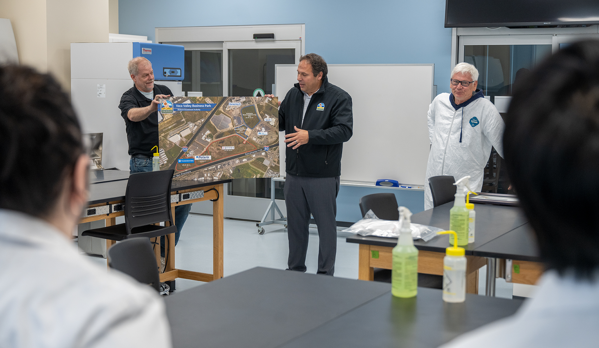 Vacaville City Manager Aaron Busch discusses the future of Biotechnology with the Solano Community College Biomanufacturing class using a map of Vacaville's Vaca Valley Business Park.  Nearly all of the vacant parcels have been purchased, with the exception of two. Professor DeKloe look on.