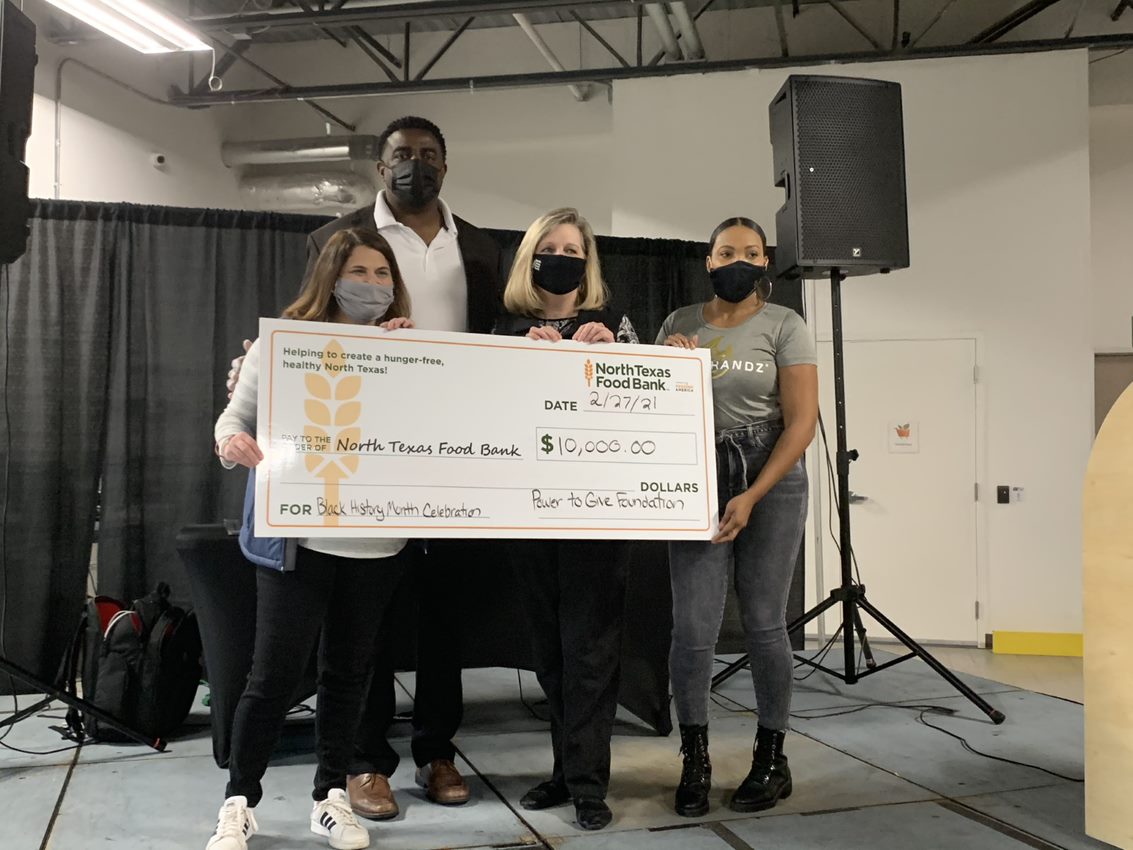 Erica Yaeger, Chief External Affairs Officer for the North Texas Food Bank, Greg Ellis, Head Coach for Texas College, Trisha  Cunningham, President and CEO of the North Texas Food Bank and Danyel Surrency Jones, CEO of POWERHANDZ and President and Chairman of the Power to Give Foundation showcase a $10,000 gift which will allow the North Texas Food Bank to provide 30,000 meals for North Texans. 