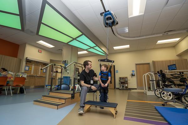 Michael Graham, a physical therapist at Children's Hospital of The King's Daughters, helps stroke patient Lucas Guinn use "ZeroG" technology to practice walking in a newly renovated rehabilitation unit. The unit is the only pediatric inpatient rehab unit in Virginia. 