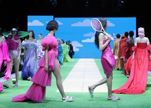 Image of models walking the runway in bright pink dresses and Naot sandals
