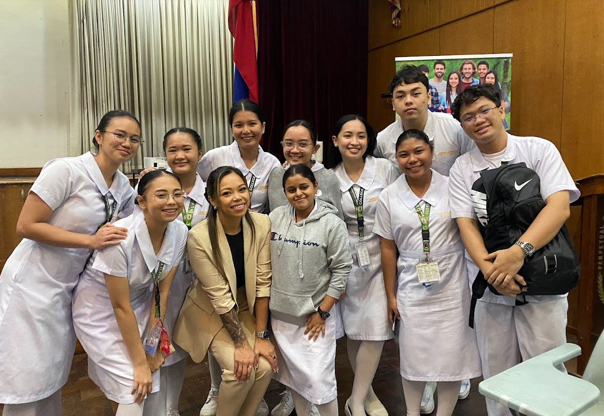 MedPro International, Senior Manager of International Testing Joely Carrillo (tan suit) poses with nursing students.