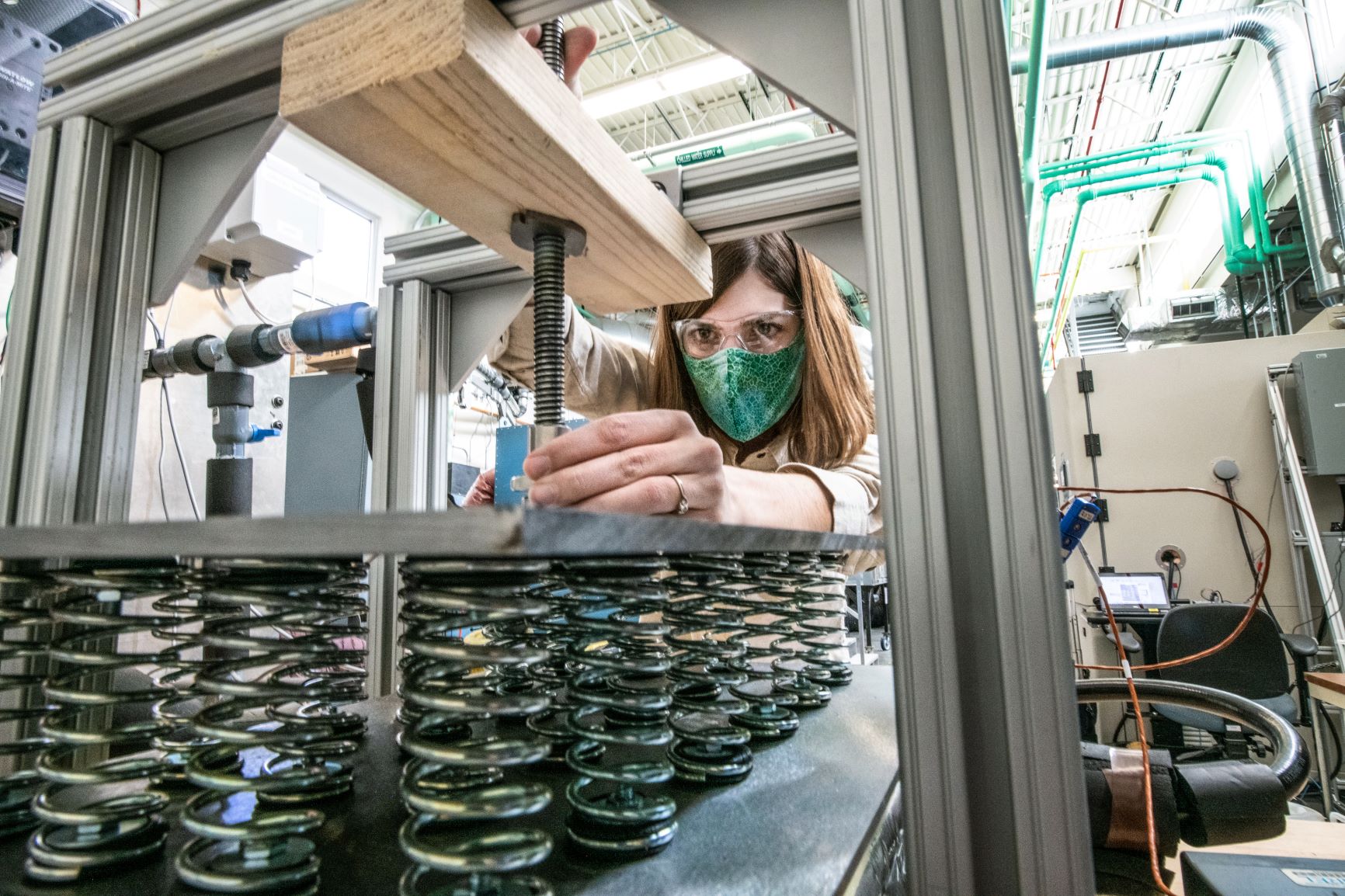 Postdoctoral researcher Allison Mahvi is investigating thermal storage at NREL's Thermal Test Facility. She is compressing the thermal storage device to improve the thermal contact between the heat exchanger and the phase change composite. This allows for charging and discharging the device more quickly. Photo by Dennis Schroeder, NREL