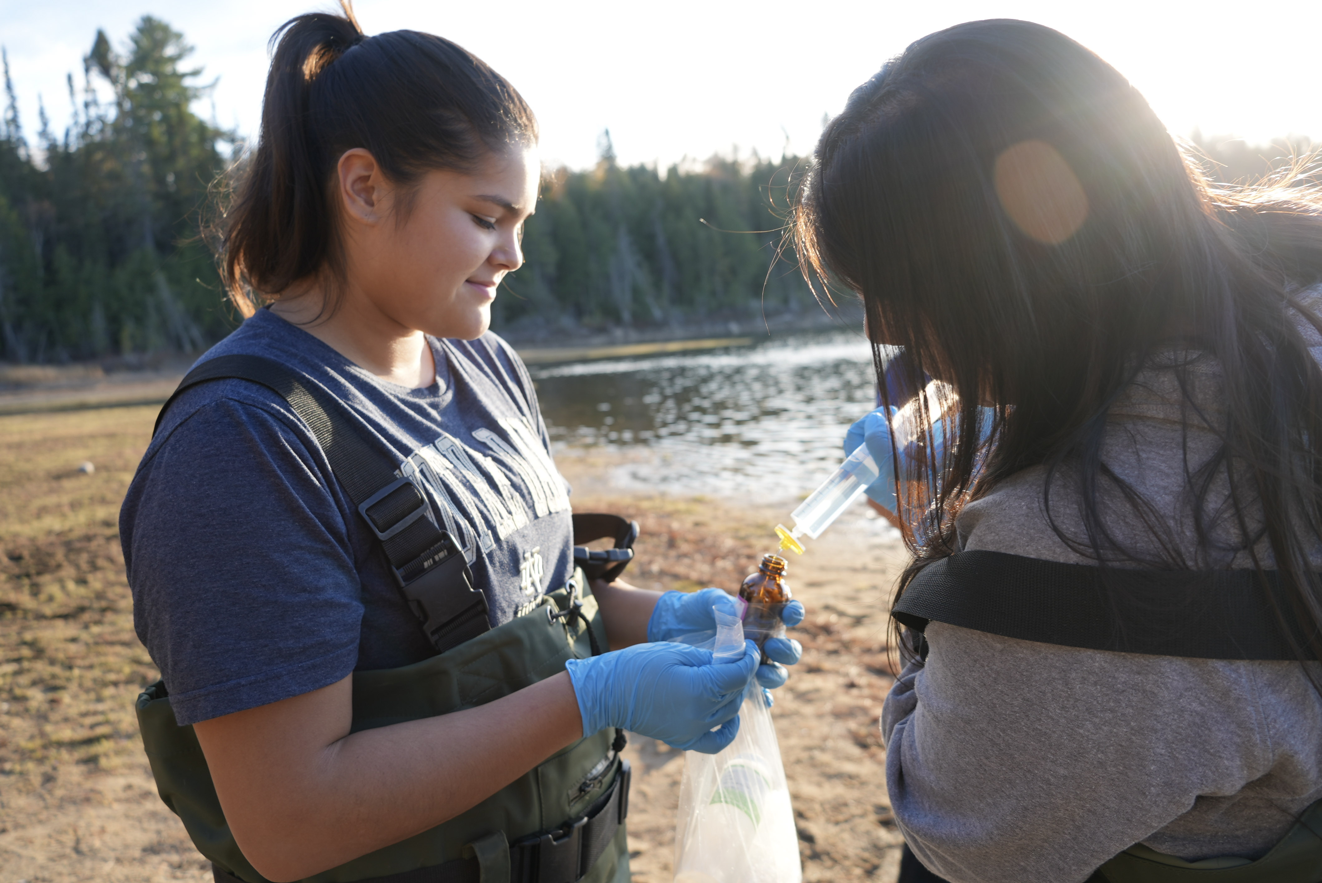 During a field workshop, intern Alexandra Nolan (left) collects a water sample as part of the Environmental Water Internship program.