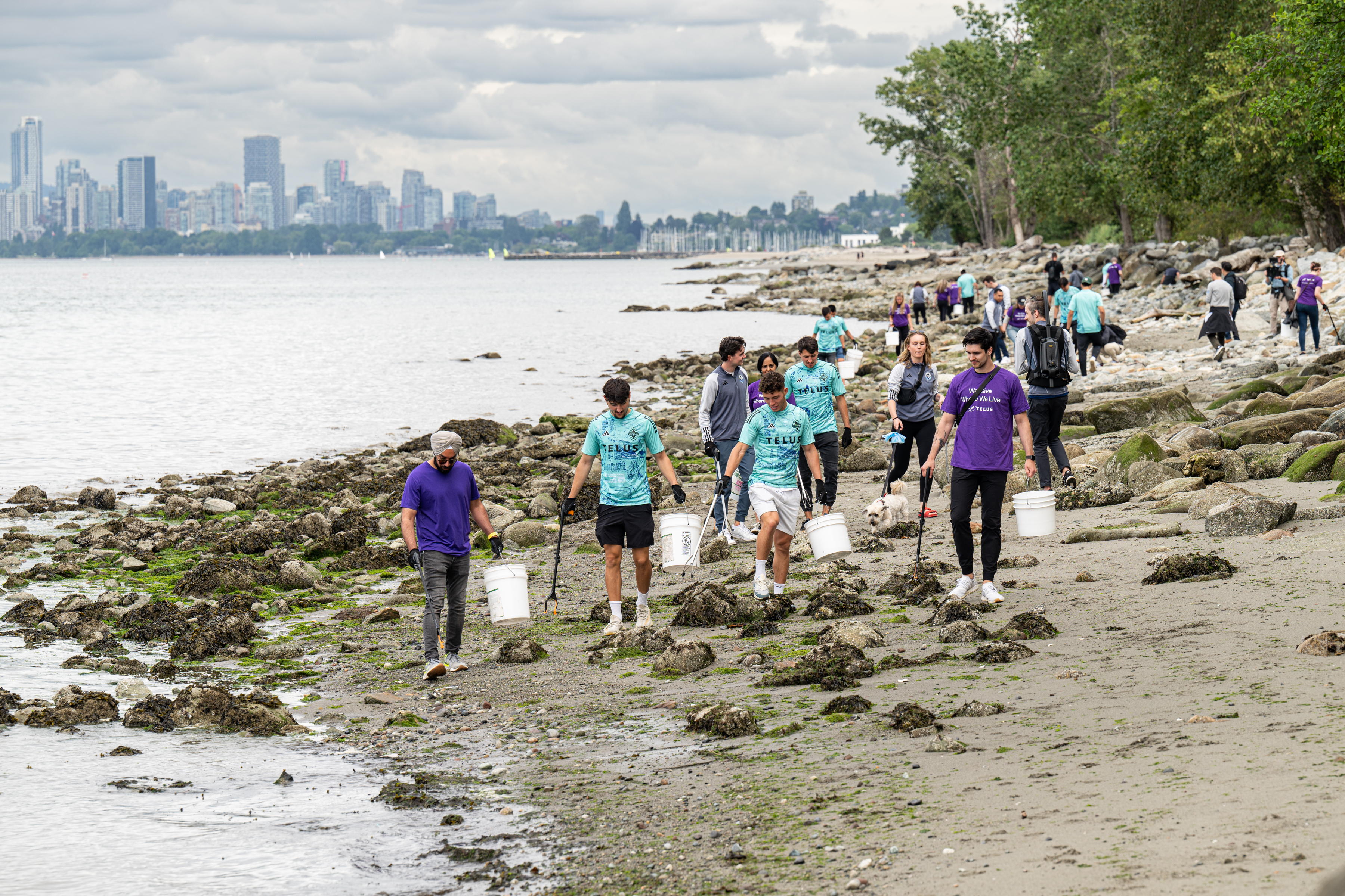 Whitecaps FC players Matteo Campagna, Sebastian Berhalter, Alessandro Schopf, alongside TELUS, collecting waste at Spanish Banks Beach. 