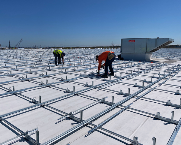 Solar Landscape installers work on putting up racking for modules on a commercial roof-top solar project.