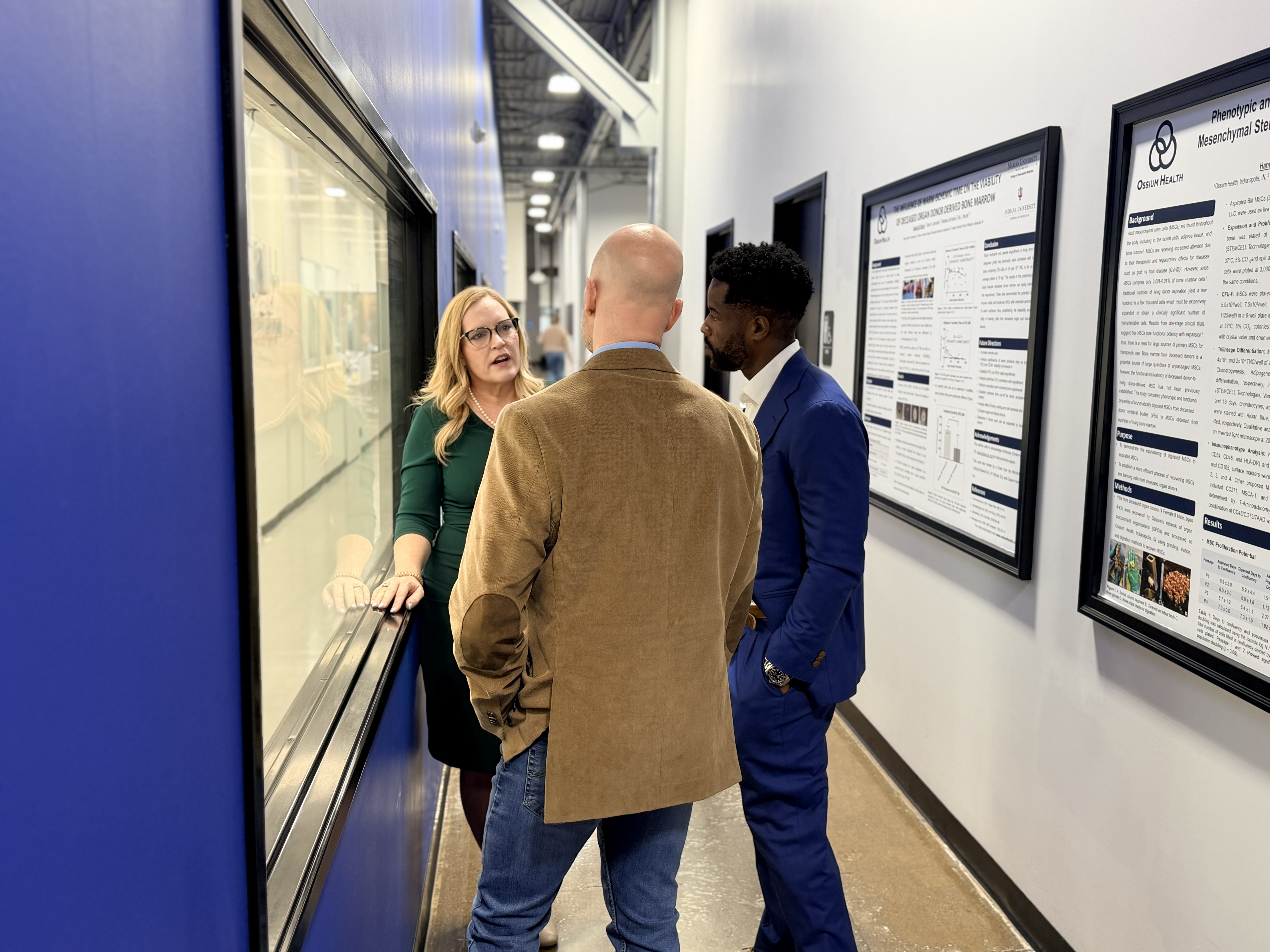 Rep. Houchin speaks with Ossium Chief Science Officer Erik Woods and CEO Kevin Caldwell in an external corridor of Ossium's production facility.