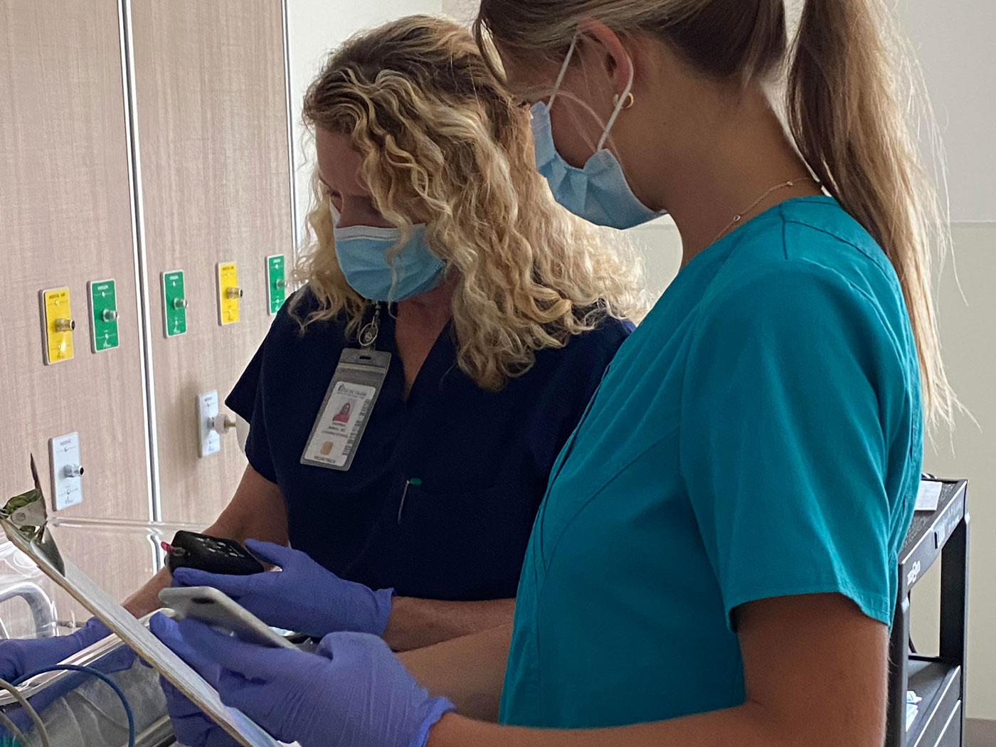 Dr. Dorothea Jenkins, M.D and assistant adjusting neurostimulation settings on the Spark Biomedical Roo device to alleviate withdrawal symptoms in babies born with Neonatal Opioid Withdrawal Syndrome.