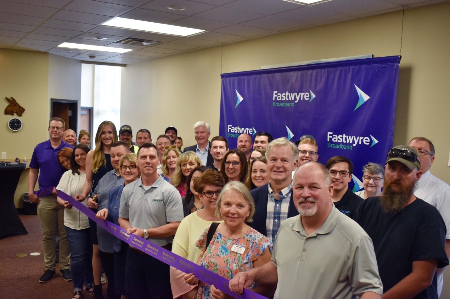 Representatives from the City of Warrensburg and state of Missouri celebrate at a recent ribbon-cutting ceremony for Fastwyre Broadband, which launched its high-speed, affordable fiber-optic network in the Warrensburg area for residents and businesses. Pictured in the front row are, from left: Greg Hall, F & C Bank Senior Vice President; Erica Jones, Open Country; Alicia Haynes, Open Country; Mariah Rudy, Fastwyre Broadband; D.J. Morris, Fastwyre Broadband; Suzanne Taylor, Warrensburg Chamber of Commerce Executive Director; Jayte Burns, Fastwyre Broadband; Stormy Taylor, Johnson County Recorder of Deeds; Jan Jones, Warrensburg City Council member and Missouri Rep. Dan Houx. Warrensburg Mayor Jim Kushner (back row, far right) welcomed Fastwyre to the Warrensburg community.