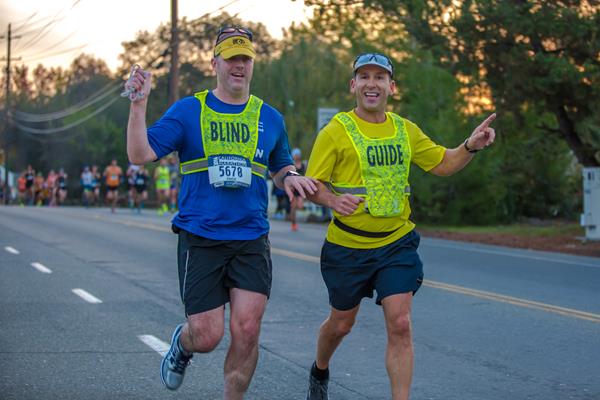 Scott Hanson (right) guides a visually impaired runner during the California International Marathon in December of 2016.
