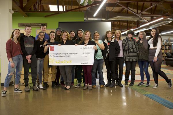 Compass Community Collaborative School poses with a giant check from Wells Fargo after winning the Global Impact Challenge. 