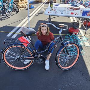 Associa Executive Vice President and CHRO Chelle O'Keefe inspects one of the 300 bikes Associa team members assembled and donated to disadvantaged kids this Christmas.