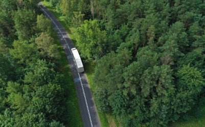 A zero emission truck drives through a forest, as the switch to clean trucking continues