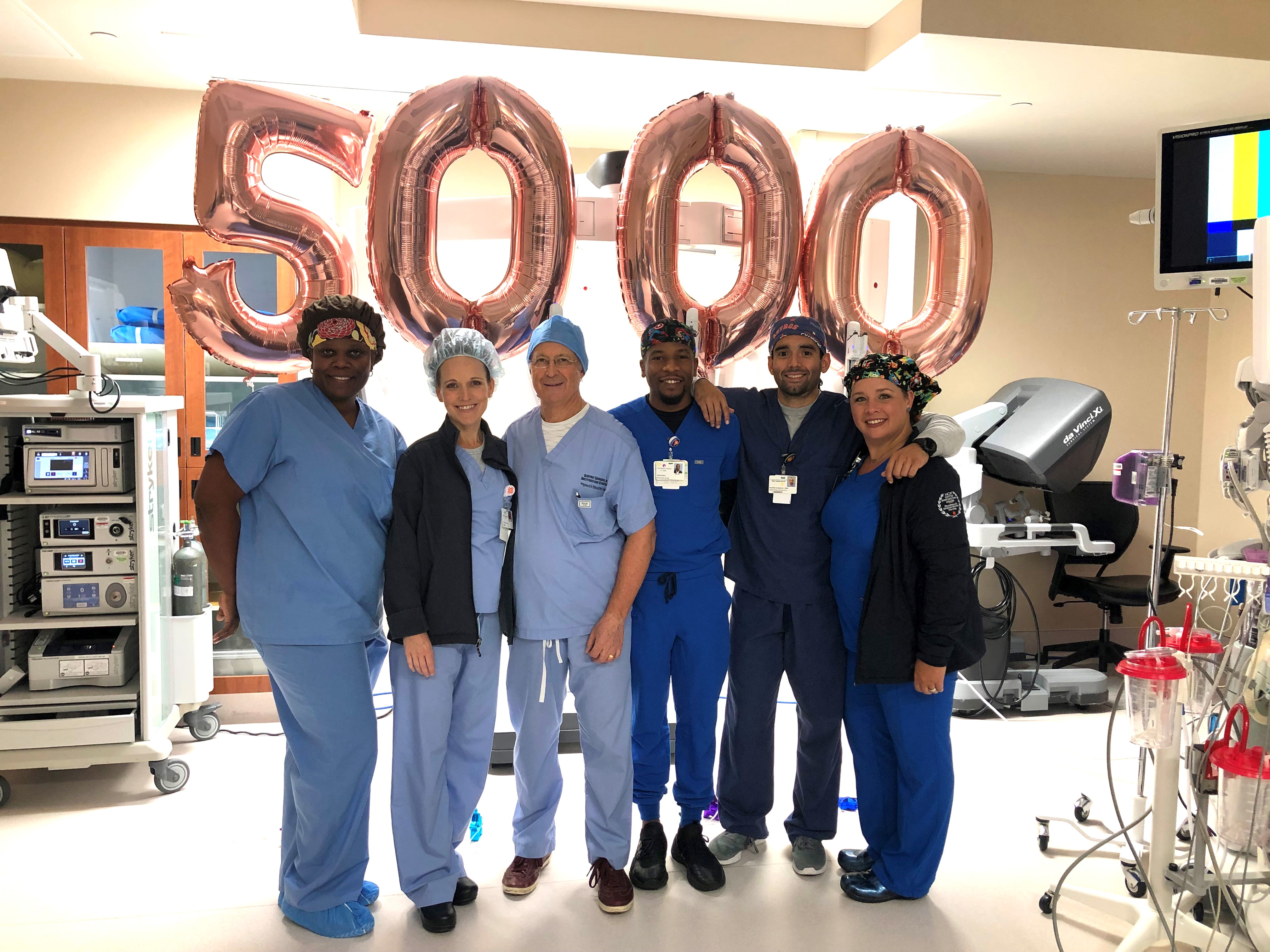 Dr. Geoffrey Schnider (third from left) celebrates the 5,000th gynecologic robotic surgery with surgical staff at The Woman’s Hospital of Texas. 