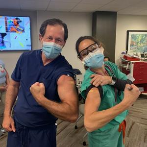 Jody Crane, MD, MBA, TeamHealth Chief Medical Officer, and Deb Vinton, MD, MBA, System Medical Director, TeamHealth Southeast Group, HCA Capital Division North, lead with their shoulders, receiving their first dose of the Pfizer-BioNTech vaccine.
