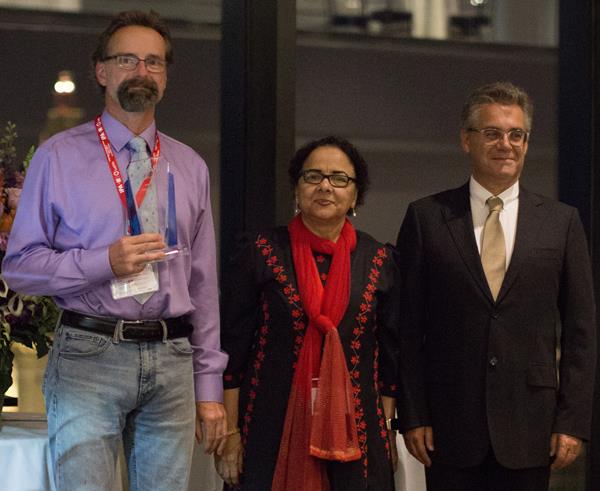 Dr. Lothar Lilge (left) receiving the 2019 Lifetime Achievement Award from IPA Past-President, Dr. Tayyaba Hassan (center), and IPA President, Dr. Luis Arnaut (right)
