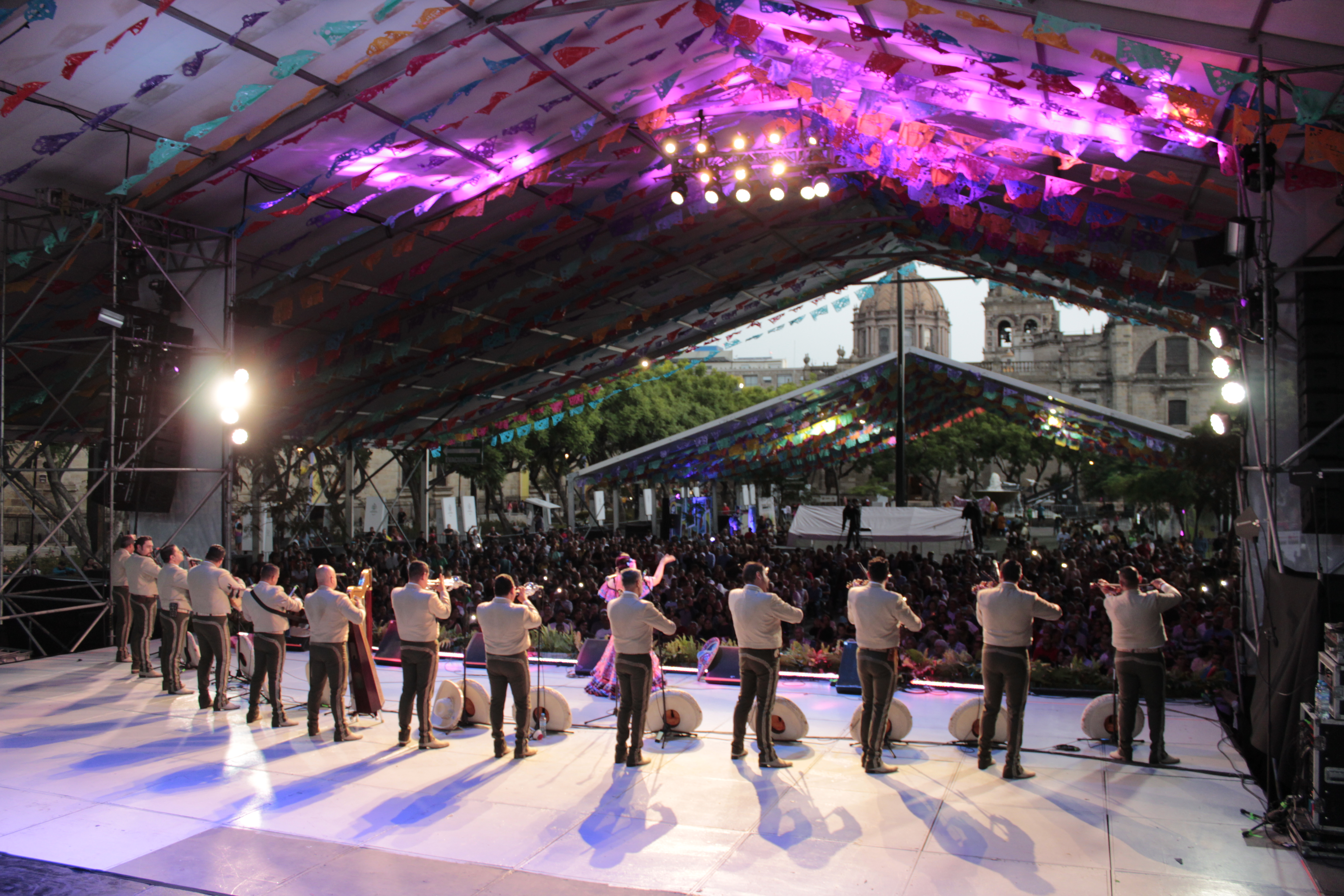 A mariachi band performs in front of a crowd