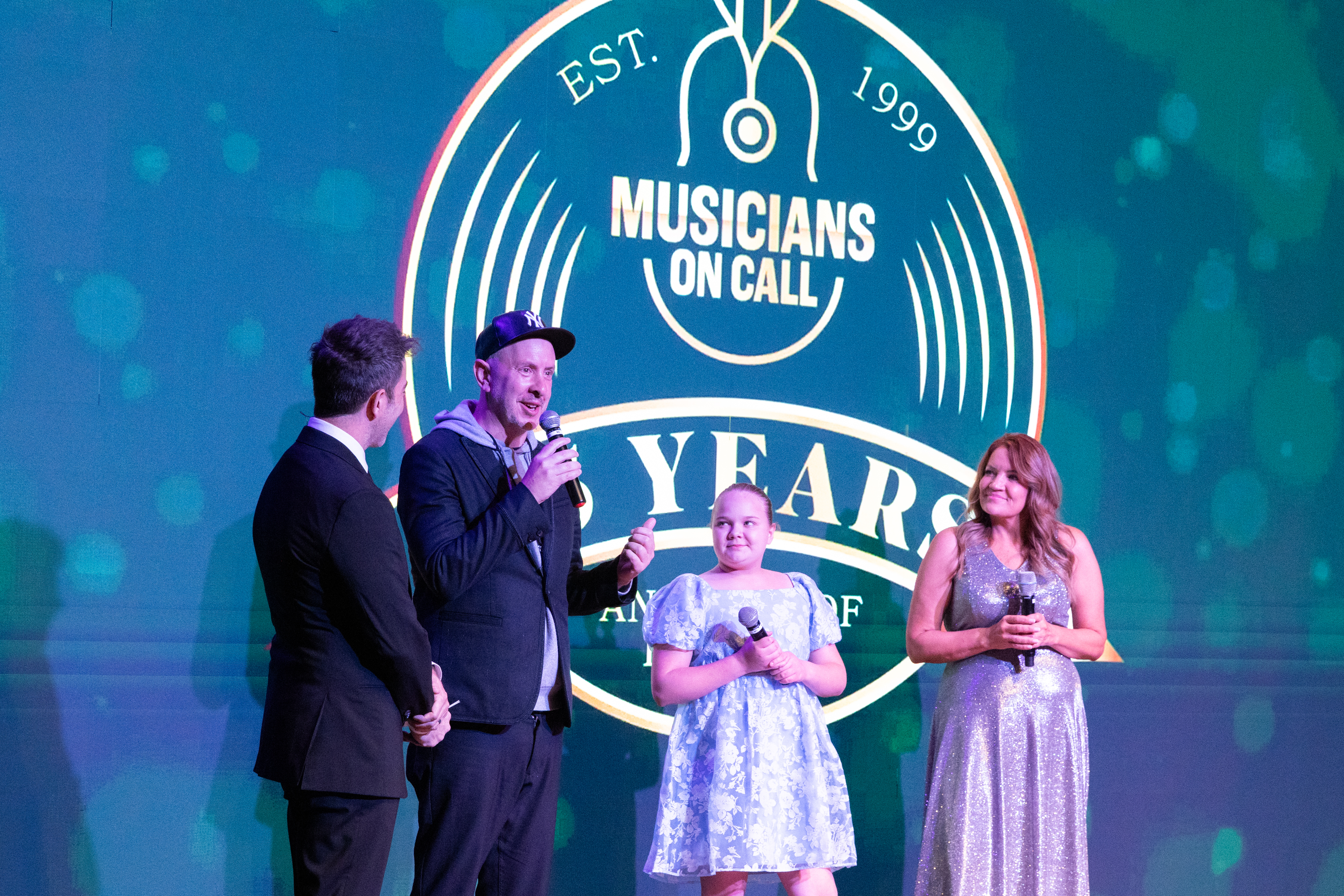 Sam Hollander and Raynie and Diana Clark speak during Musicians On Call's 