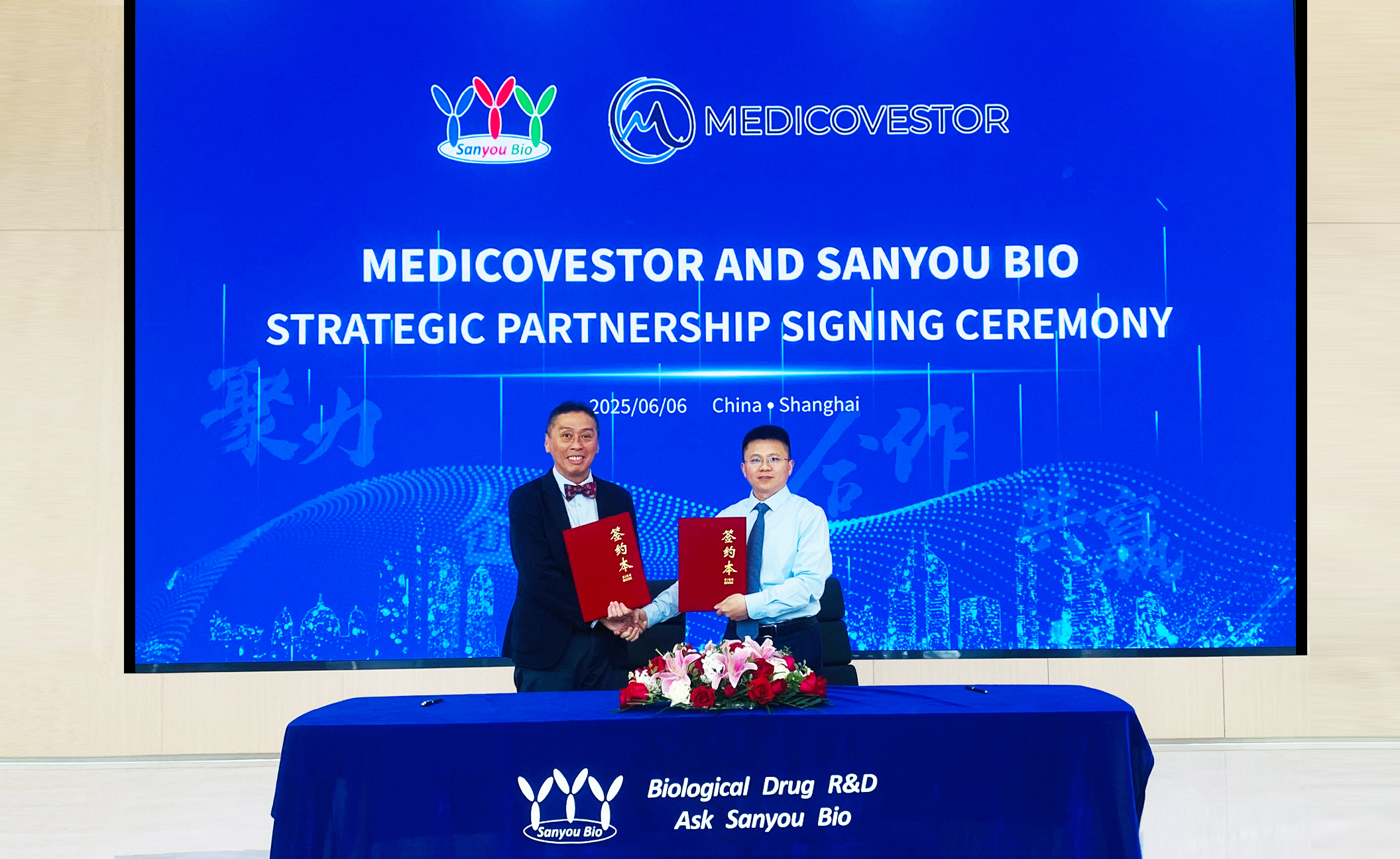 Dr. Seah Lim, CEO of Medicovestor, and Dr. Guojun Lang, CEO of Sanyou Biopharmaceuticals holding the partnership agreement.