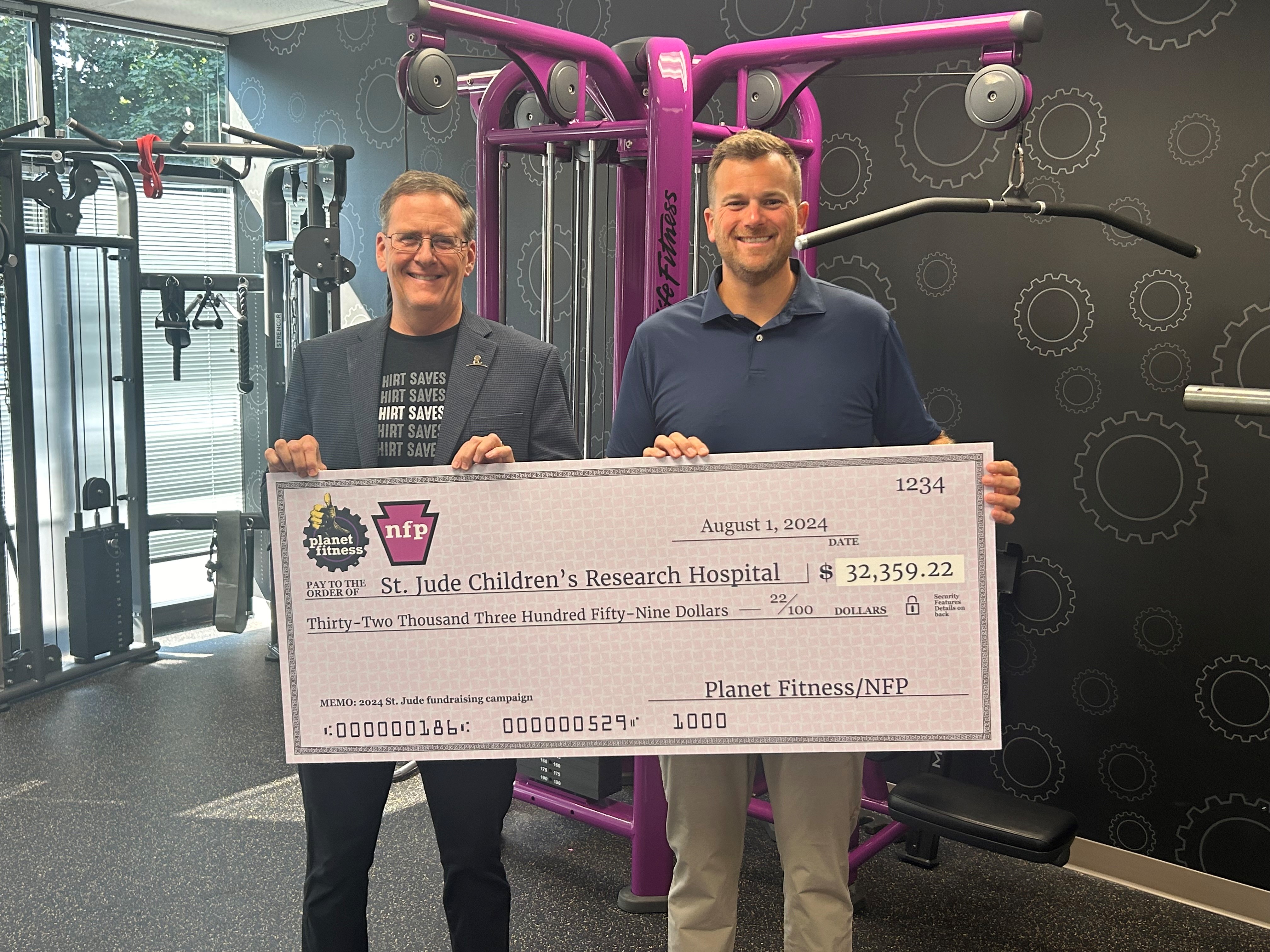 Stephen Kindler, Jr., President and CEO of National Fitness Partners, presents a check for $32,359.22 to Kevin O’Brien, of St. Jude, representing NFP’s generous contribution as part of a larger $36,000 donation to support St. Jude's mission.