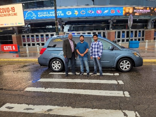 ModivCare Inc. (“ModivCare”) is providing much-needed, door-to-door transportation services to Michigan residents in Wayne, Oakland, and Macomb counties wishing to receive a COVID-19 vaccine from the mass vaccination site at Ford Field in Detroit. Pictured here in front of Gate A at the Ford Field vaccination site, from left: Donald Scott, Provider Relations Manager for ModivCare, and co-owners Mohammed (Ron) Haque and Mohammed (Mike) Haque of M RUN LLC, which is the local transportation partner offering rides to local residents to/from the vaccination site.