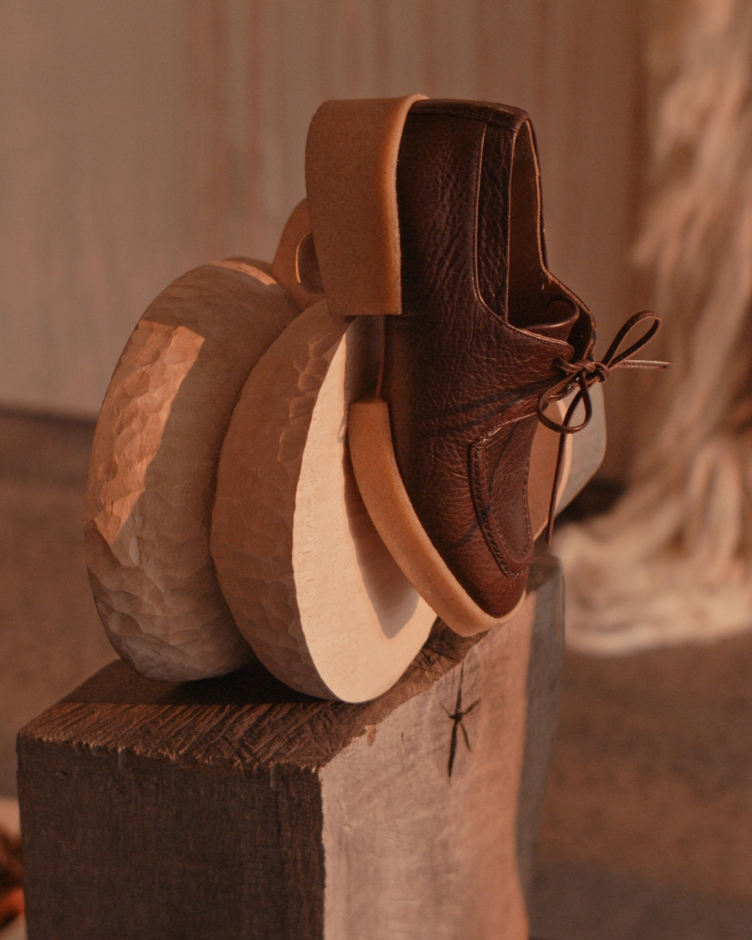Brown lace-up Oxford with a light natural crepe sole displayed against carved wooden forms.
