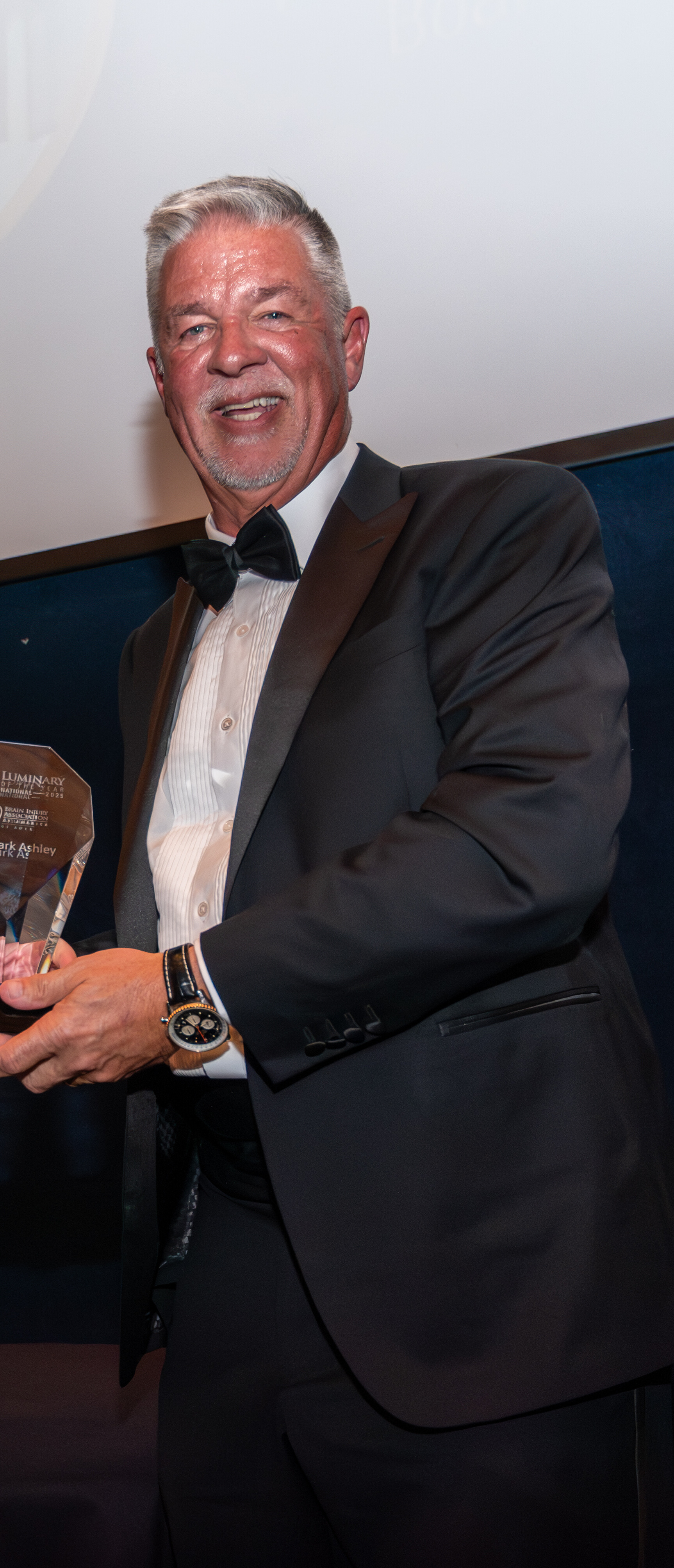 Dr. Mark Ashley holding the Brain Injury Association of America National Luminary of the Year trophy