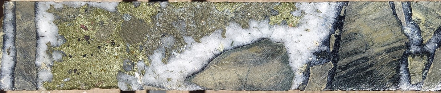 Quartz-rich high-grade breccia in Hole 39: Sericite-tourmaline-altered siltstone clasts coated in a rind of euhedral quartz-tourmaline and supported in a chalcopyrite-pyrite matrix. SFDH-039, 410.2m. From a 1m sample that averaged 0.72 g/t gold, 65 g/t silver and 2.3 % copper. Photograph is of a selected interval and is not necessarily representative of mineralisation hosted throughout the property.
