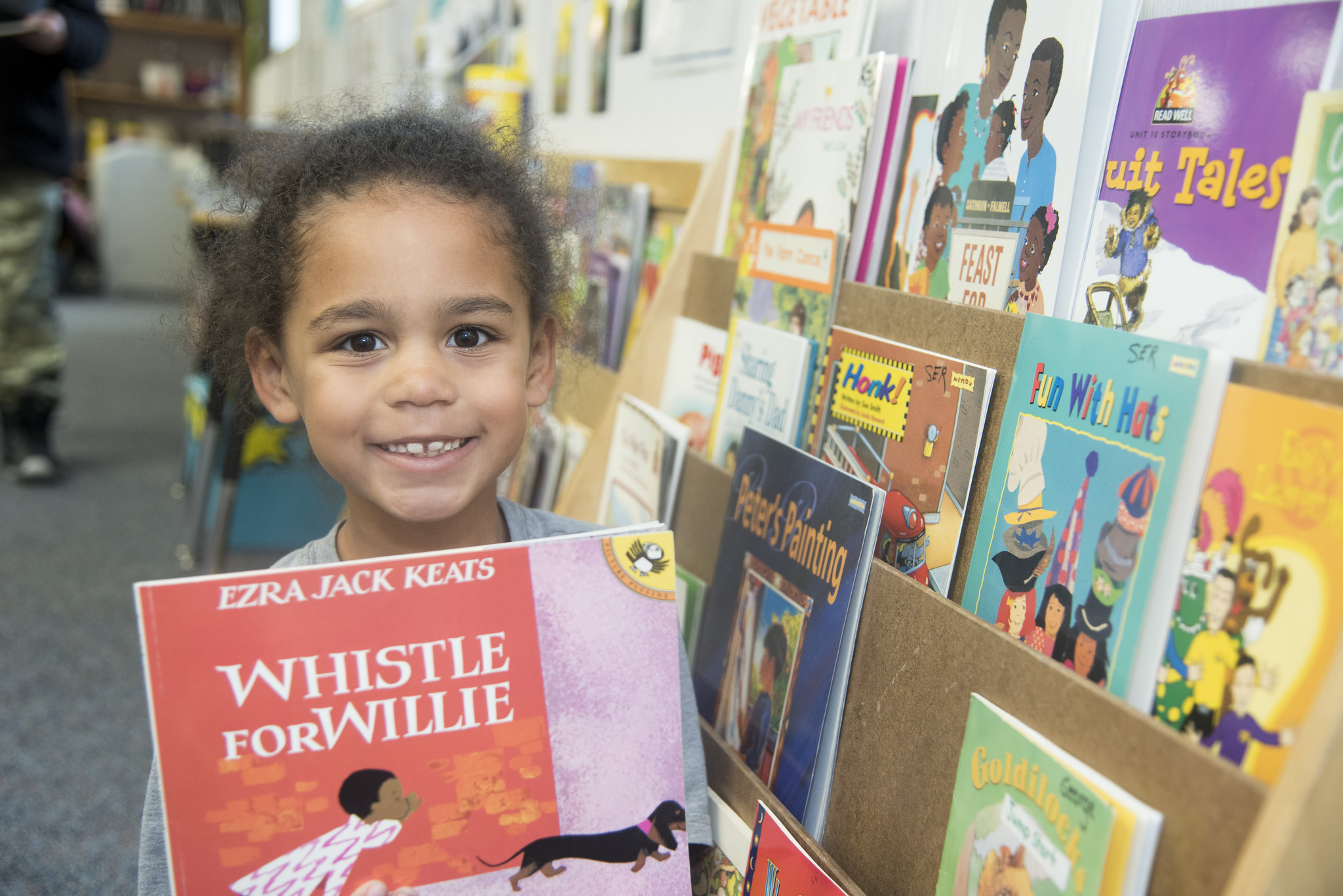 A Reading Partners student selecting a book