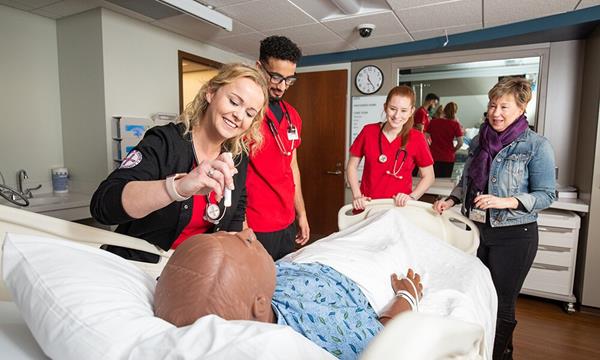 Professor Betsy Cambridge (right) oversees a simulation performed by nursing students (from left) Sherrie Anderson ('19), Kassim Nasser ('19), and Kimmy Thompson ('19).