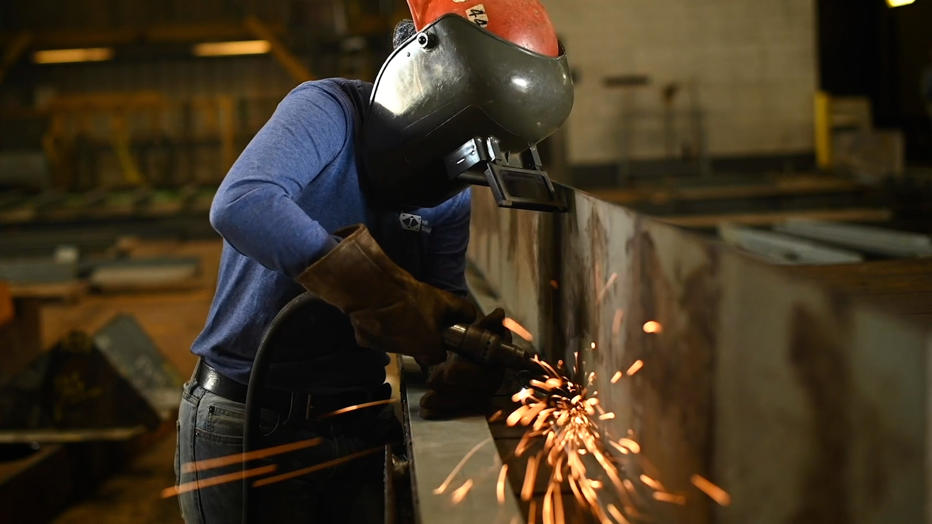 An employee from HII's Ingalls Shipbuilding division grinds metal during construction of a ship. With over 500 different jobs, visit buildyourcareer.com to search job descriptions, job listings, and apply online.
