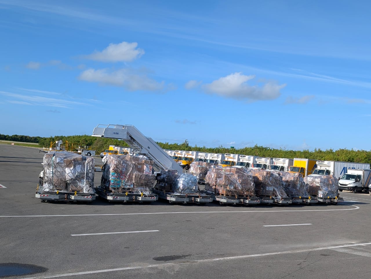 Pallets of humanitarian relief supplies staged on the airport apron before air transport to Venezuela.