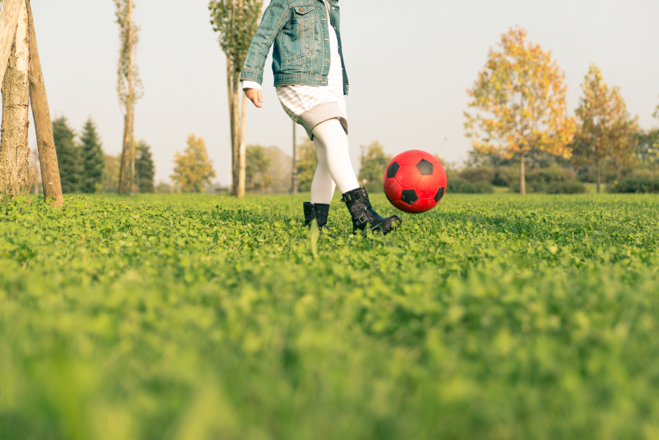 Girl kicks soccer ball in park. Fabio Formaggio | Dreamstime.com
