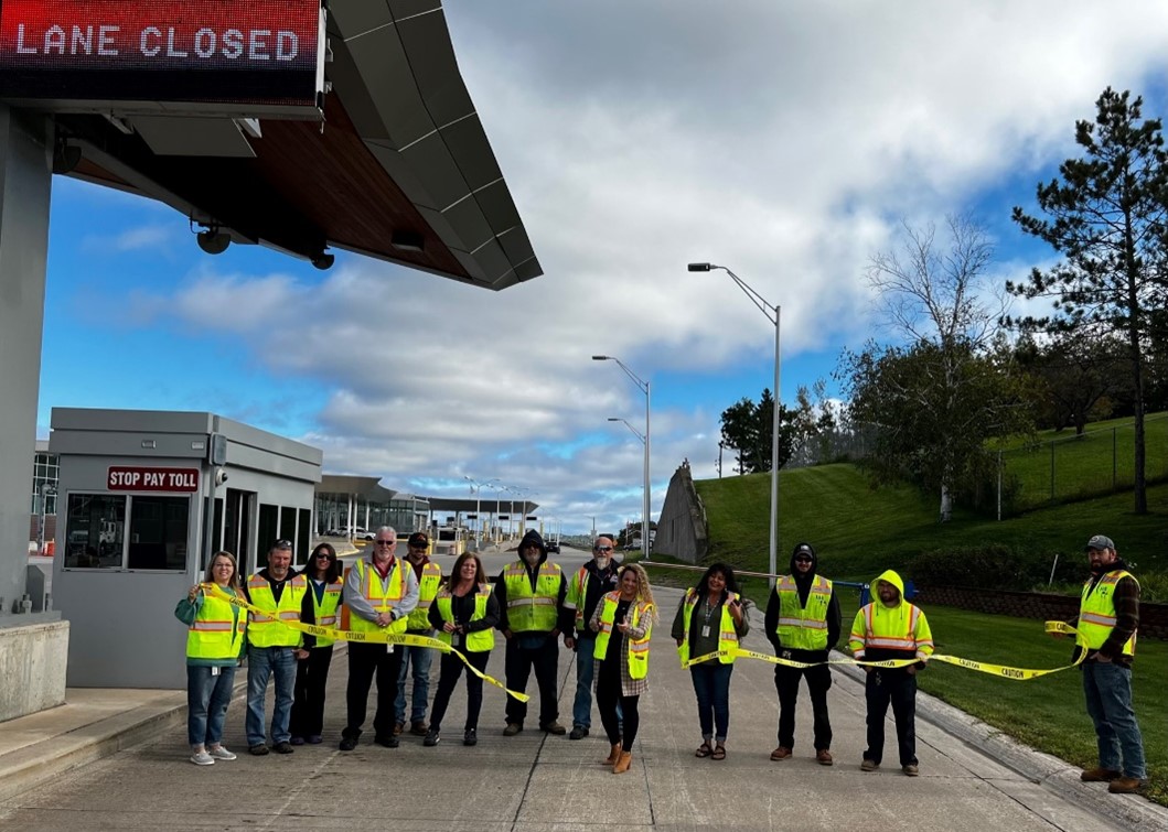 Staff from the International Bridge Administration cut the ribbon on the new toll system at the International Bridge between Sault Ste. Marie Michigan and Sault Ste. Marie Ontario. (MDOT photo)