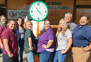 Minuteman Press franchise owner Peter Castorena (right) and his team in Lancaster, CA with their Giant Minute Man.