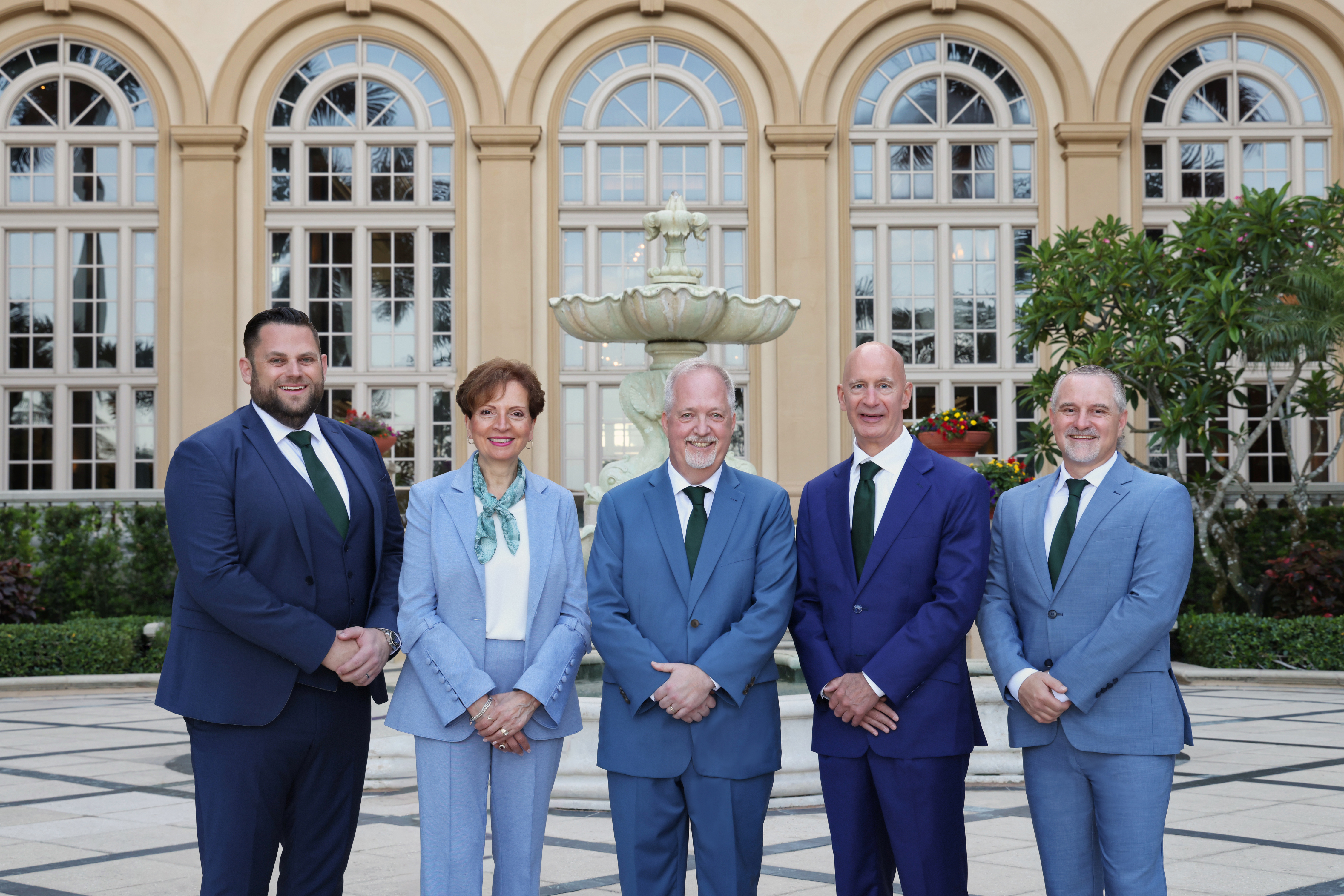 Members of the 2027 MDRT Executive Committee pose together for a group portrait outdoors in front of a fountain and arched windows.