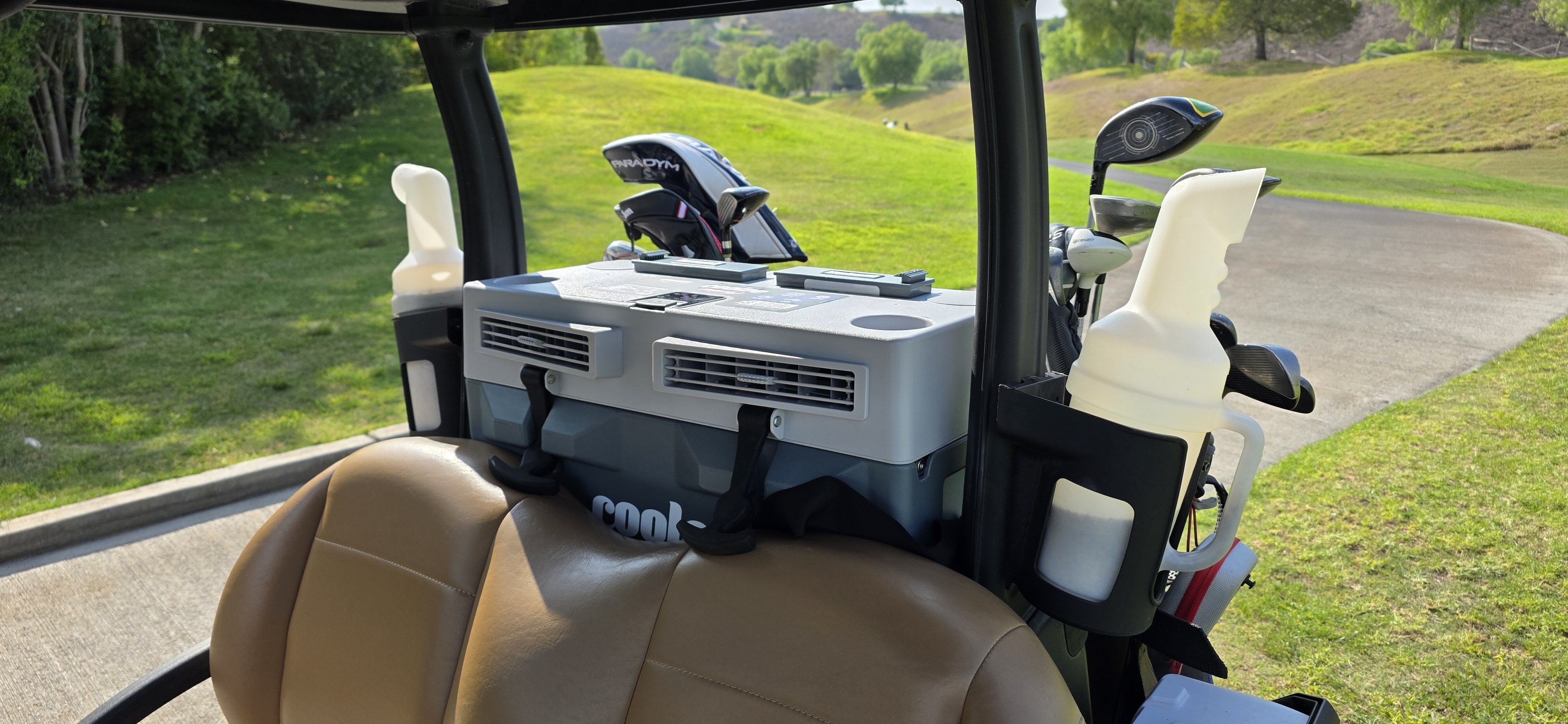 Front view of a Cool Boss by BendPak Coolee Tour LX portable air conditioner in a golf cart’s rear basket. 