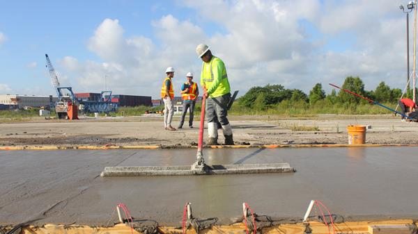 A worker with the Louisiana Transportation Research Center spreads a section of engineered cementitious composite, or ECC, overlay for further testing by LSU Construction Management researchers.