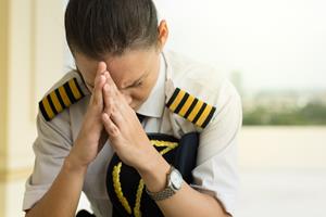 A female pilot receives bad news while travelling. 