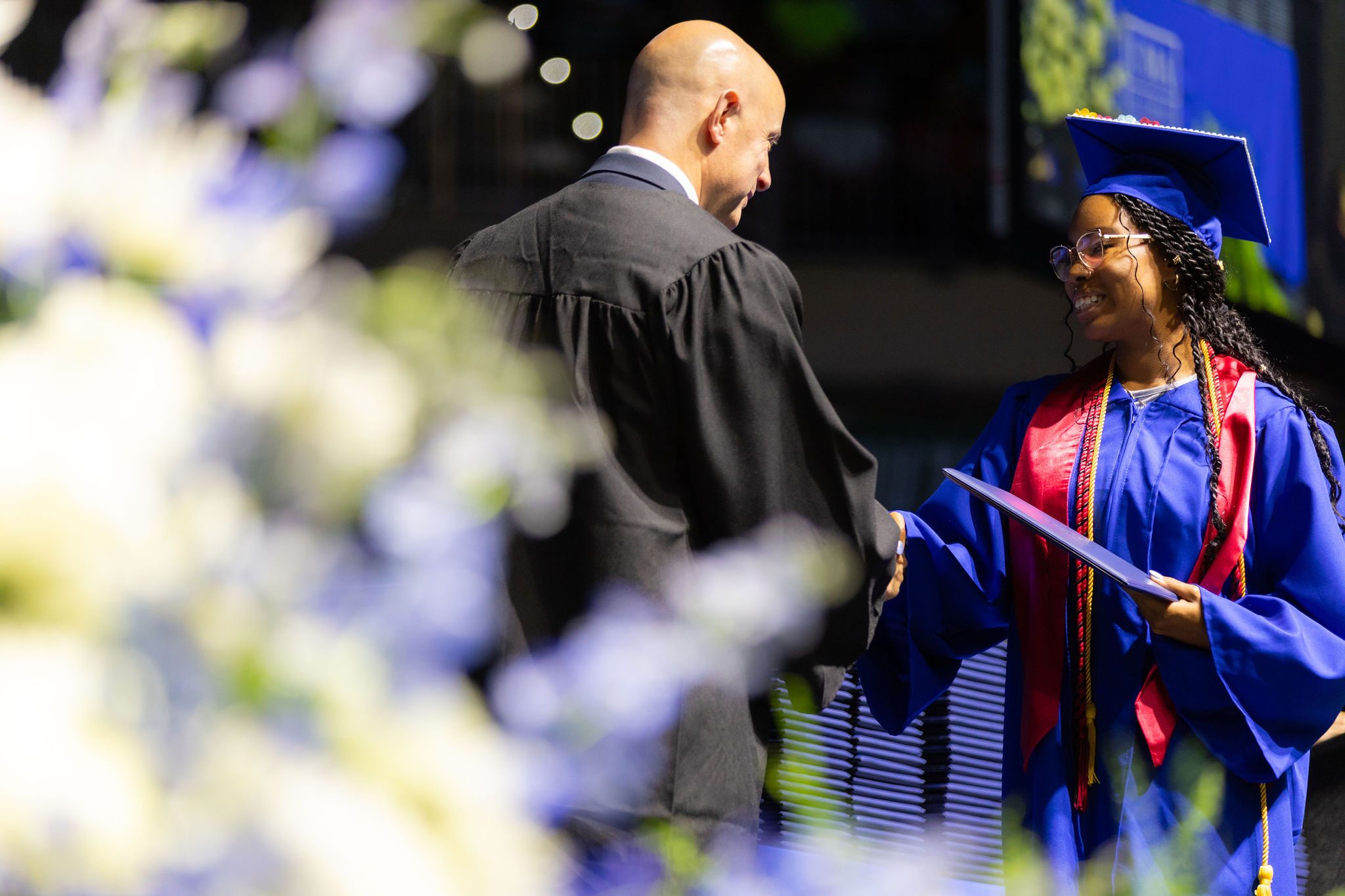 Simone Nelson, UMA graduate and student speaker, shakes hands with UMA President Thomas Rametta after receiving her diploma on stage at the September 14, 2024 commencement ceremony.