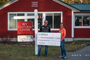 Tim Smith, President and General Manager of Waterville Valley Resort, presents $10,000 scholarship donation to Leal Elliot, Executive Director of the Rey Cultural Center.